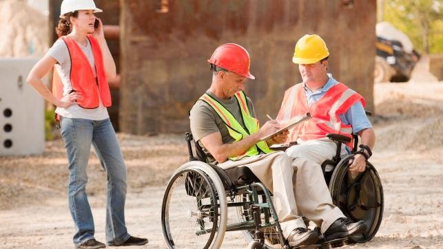 Project engineers in wheelchairs discussing plans on site